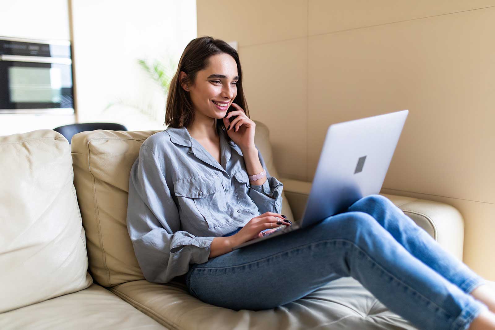 Woman doing online mortgage research while lounging on her couch