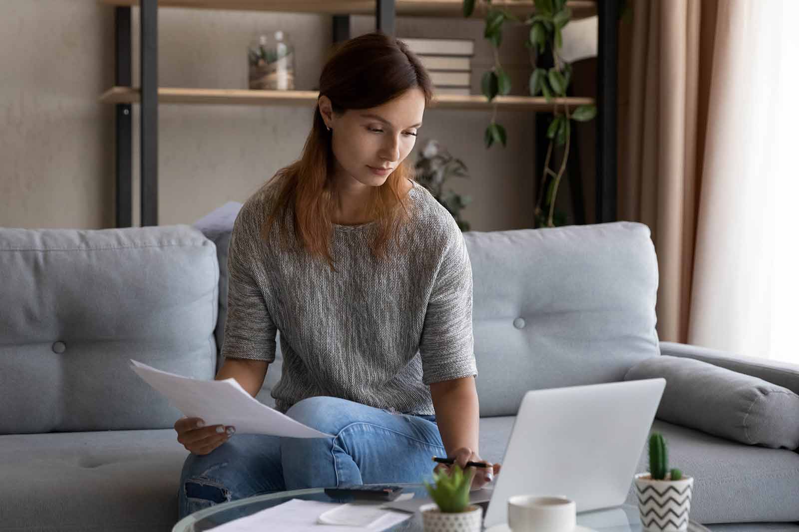 woman sitting in her living room doing online mortgage research
